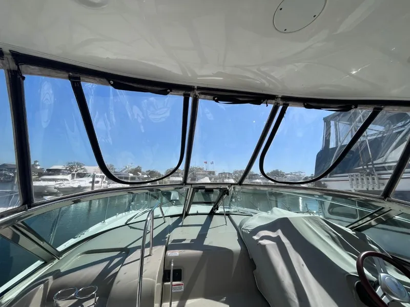 Slide: The Image of Interior view of 2010 Sea Ray 350 Sundancer yacht, featuring clear windows and covered controls. - 13