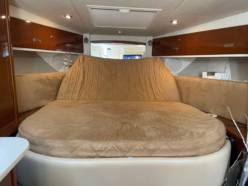 Slide: The Image of Interior cabin of 2010 Sea Ray 350 Sundancer with beige bedding and wooden cabinets. - 32