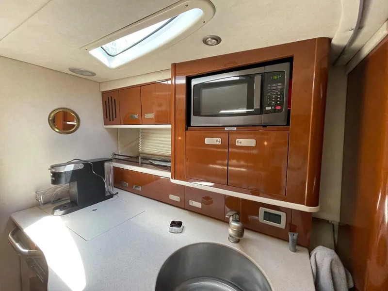 Slide: The Image of Interior of 2010 Sea Ray 350 Sundancer kitchen with microwave and modern amenities. - 36