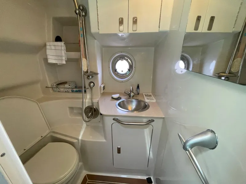 Slide: The Image of 2010 Sea Ray 350 Sundancer bathroom with sink, toilet, shower, and porthole window. - 39