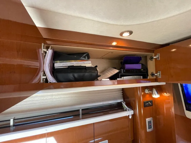 Slide: The Image of Cabinet storage inside 2010 Sea Ray 350 Sundancer yacht, featuring organized documents and accessories. - 40