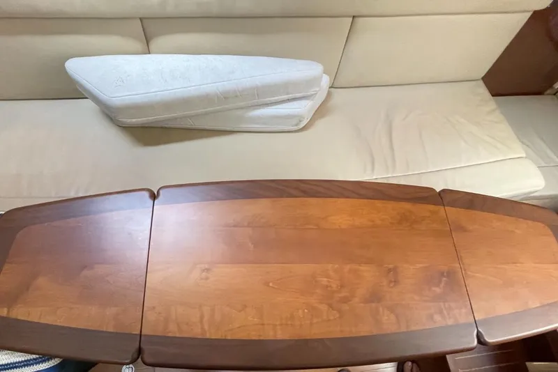 Slide: The Image of Interior of 2010 Sea Ray 350 Sundancer with wooden table and beige seating. - 42