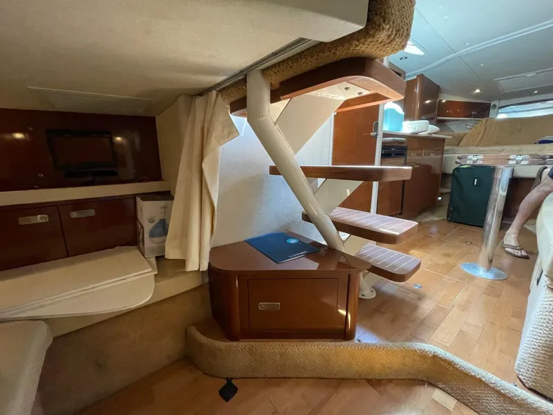 Slide: The Image of Interior of 2010 Sea Ray 350 Sundancer yacht, featuring wooden stairs and cozy seating area. - 48