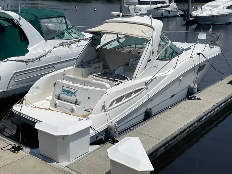 Slide: The Image of 2010 Sea Ray 350 Sundancer docked at marina, featuring sleek design and spacious deck. - 7