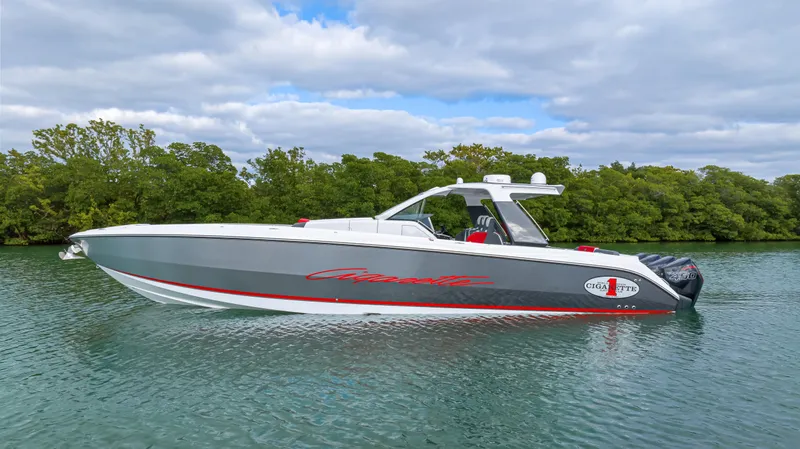 The Image of 2022 Cigarette 42 Auroris boat on calm water with lush green background. - 1