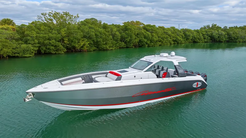 Slide: The Image of 2022 Cigarette 42 Auroris boat on calm water, surrounded by lush greenery. - 2