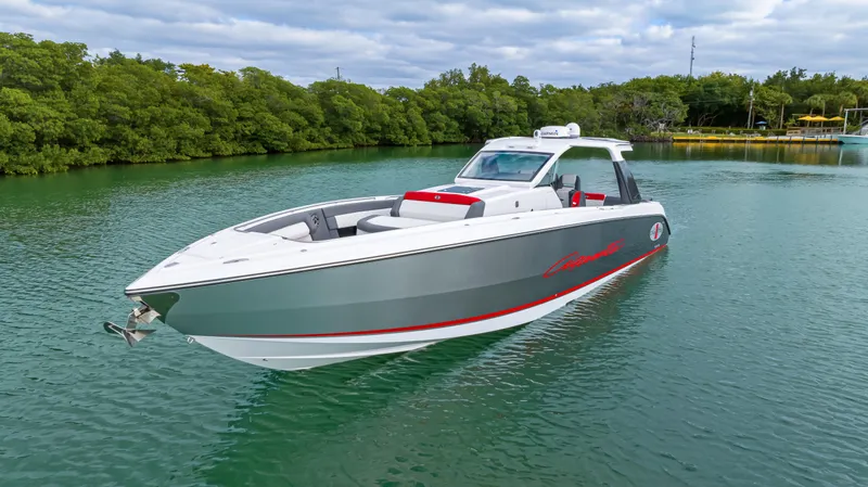 Slide: The Image of 2022 Cigarette 42 Auroris boat on calm water, surrounded by lush greenery. - 3