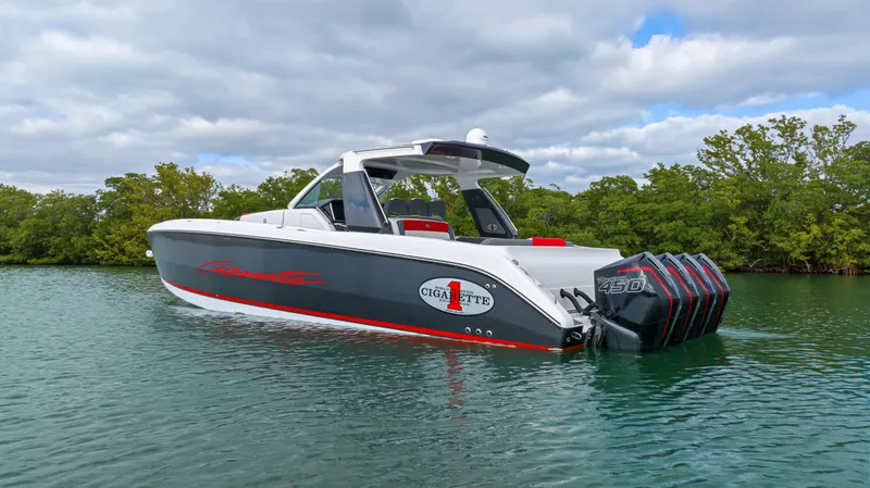 Slide: The Image of 2022 Cigarette 42 Auroris boat on calm water with lush greenery background. - 5