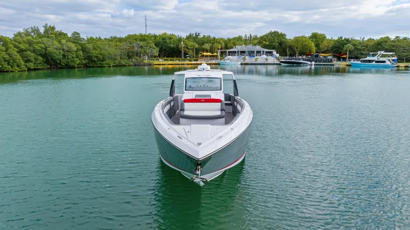 Slide: The Image of 2022 Cigarette 42 Auroris boat on calm water, surrounded by lush greenery. - 6