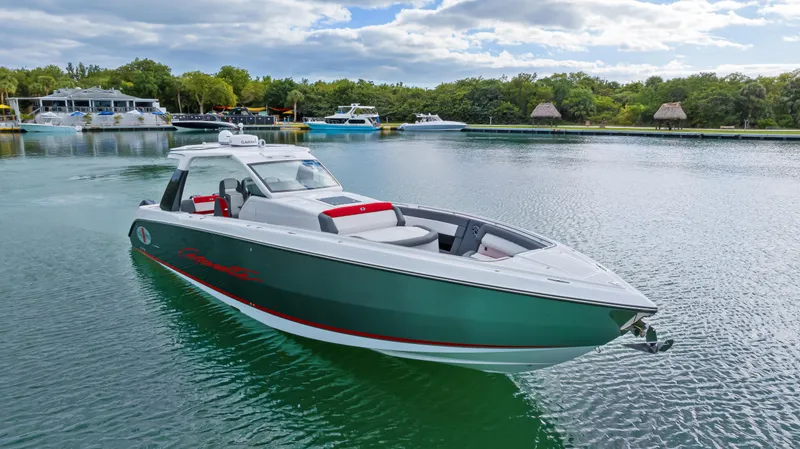 Slide: The Image of 2022 Cigarette 42 Auroris boat on calm water, surrounded by lush greenery and other boats. - 7