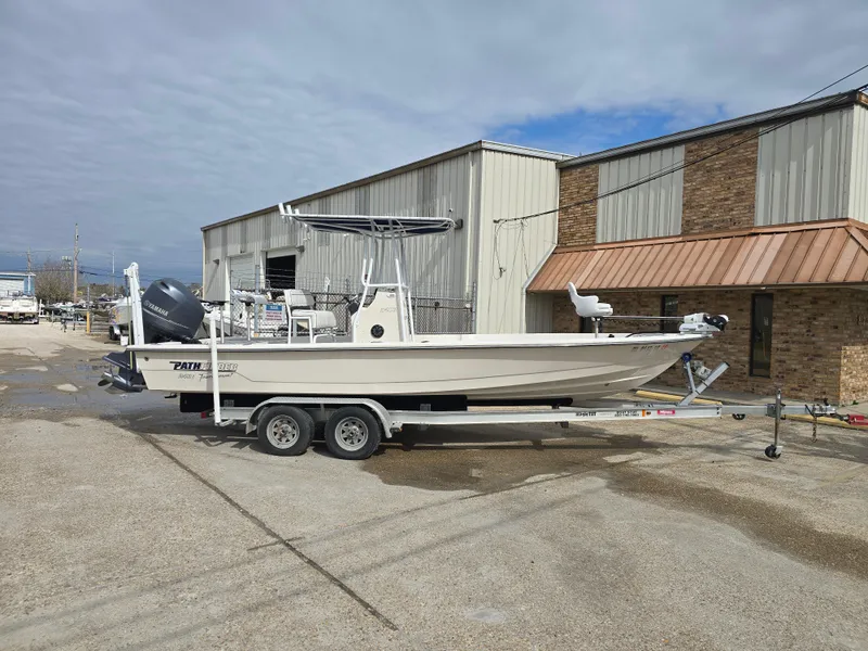 Slide: The Image of 2006 Pathfinder 2400 TRS boat on trailer, parked outside industrial building. - 2