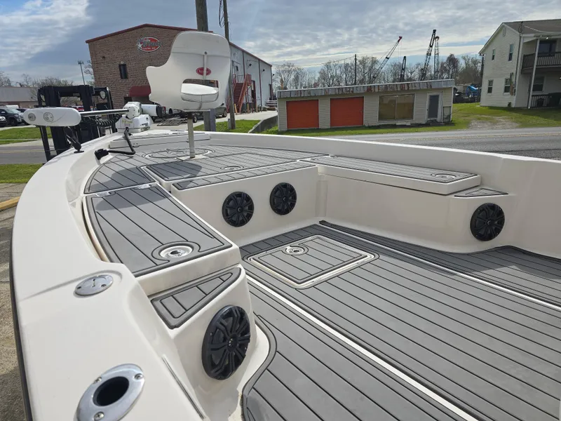 Slide: The Image of 2006 Pathfinder 2400 TRS boat deck with seating and speakers, docked near buildings. - 7