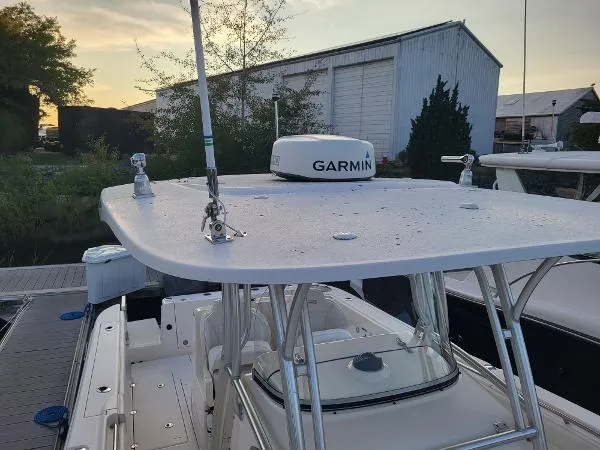 Slide: The Image of 2014 Robalo R 300 boat with Garmin radar, docked near a warehouse at sunset. - 11