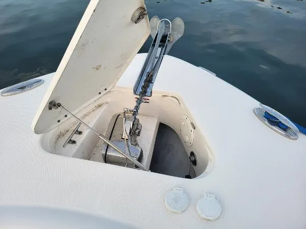 Slide: The Image of 2014 Robalo R 300 boat anchor compartment open on calm water. - 12