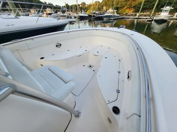 Slide: The Image of 2014 Robalo R 300 boat interior, featuring spacious seating and sleek design in a marina setting. - 14
