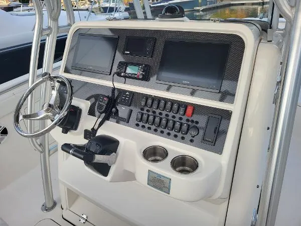 Slide: The Image of 2014 Robalo R 300 boat dashboard with steering wheel and electronic controls. - 20
