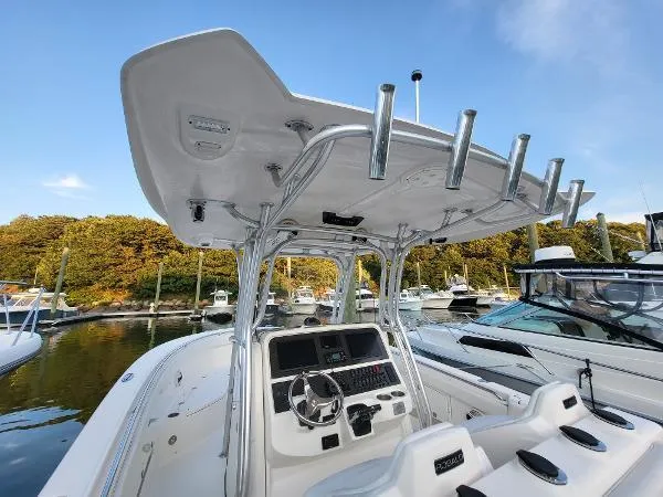 Slide: The Image of 2014 Robalo R 300 boat console with T-top, docked in a marina. - 24