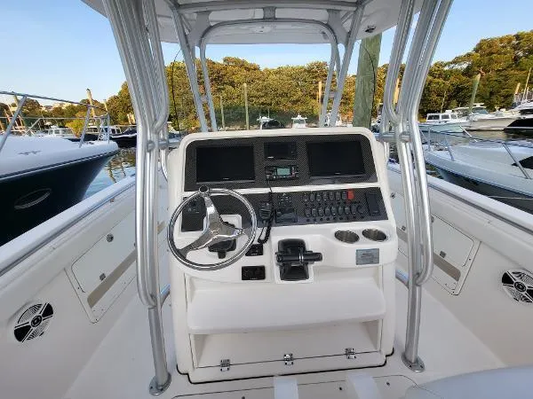 Slide: The Image of 2014 Robalo R 300 boat helm with steering wheel and control panel. - 25