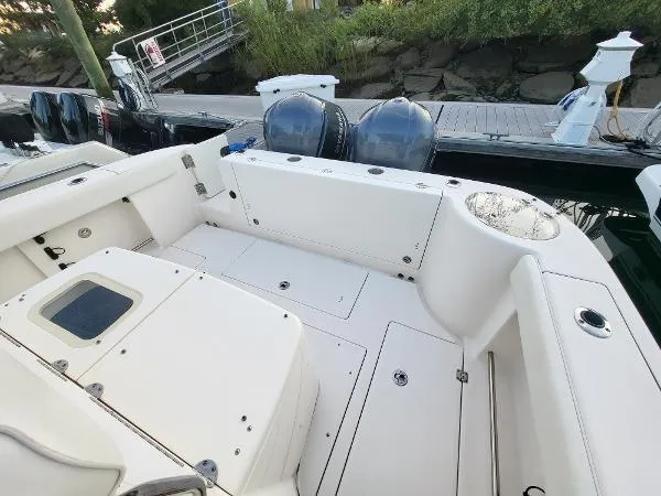 Slide: The Image of 2014 Robalo R 300 boat deck with dual engines, docked by a wooden pier. - 29