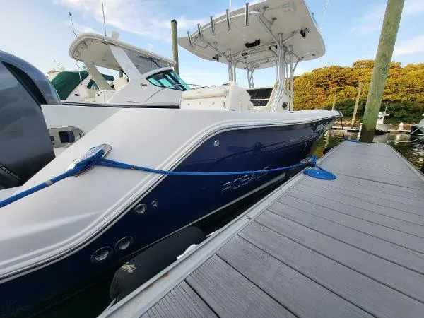 Slide: The Image of 2014 Robalo R 300 boat docked, featuring sleek design and blue hull. - 3