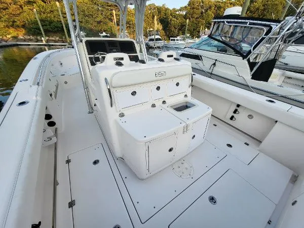 Slide: The Image of 2014 Robalo R 300 boat interior with seating and storage, docked near other boats. - 30
