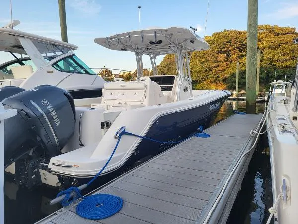 Slide: The Image of 2014 Robalo R 300 boat docked, featuring Yamaha outboard engines and sleek design. - 4