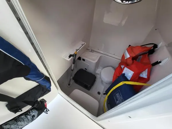 Slide: The Image of 2014 Robalo R 300 boat interior with life jackets and marine toilet. - 6