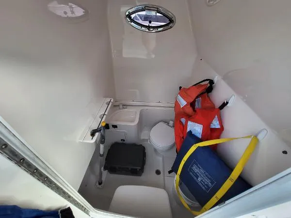 Slide: The Image of 2014 Robalo R 300 boat interior with life jackets and marine toilet. - 7