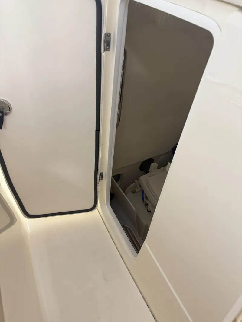 Slide: The Image of 2022 Scout 255 LXF boat storage compartment with open door. - 11