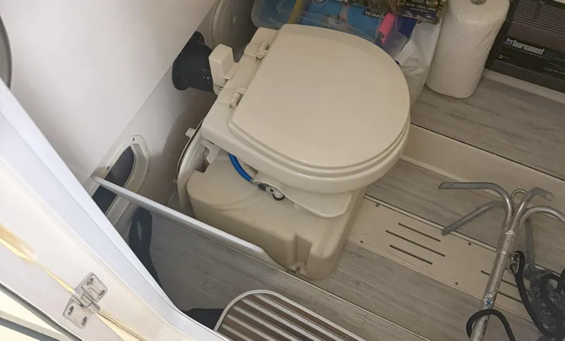 Slide: The Image of 2022 Scout 255 LXF boat interior with compact marine toilet and accessories. - 14