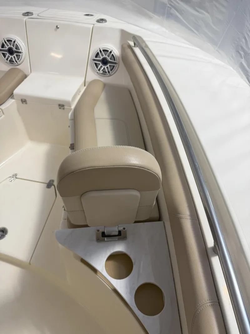 Slide: The Image of 2022 Scout 255 LXF boat interior with beige seating and cup holders. - 16