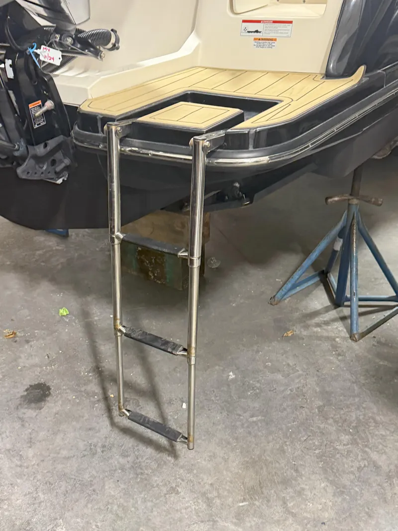 Slide: The Image of 2022 Scout 255 LXF boat with stainless steel swim ladder in a garage setting. - 19