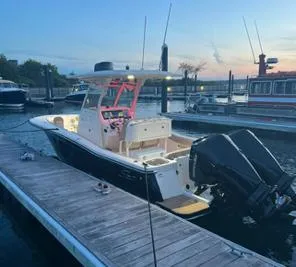 Slide: The Image of 2022 Scout 255 LXF boat docked at marina during sunset. - 2