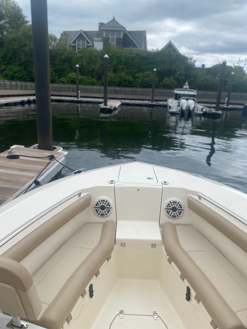 Slide: The Image of 2022 Scout 255 LXF boat docked in a marina with waterfront view. - 23