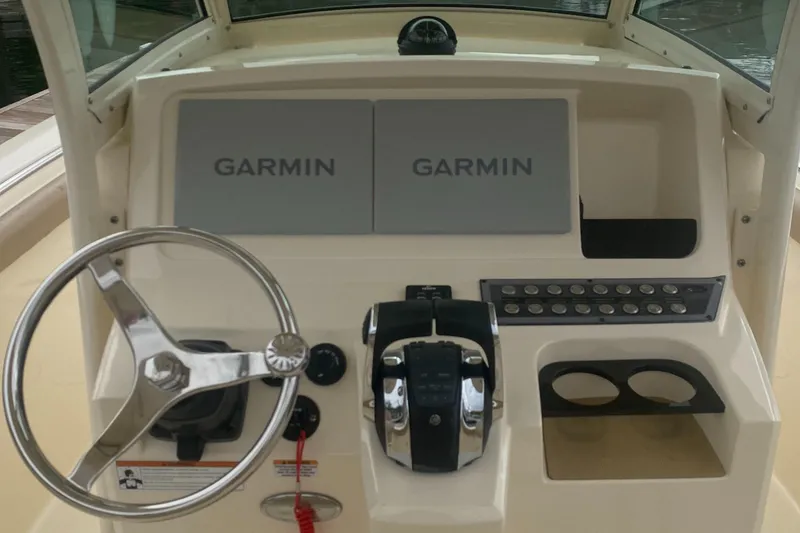Slide: The Image of 2022 Scout 255 LXF boat dashboard with Garmin displays and steering wheel. - 26