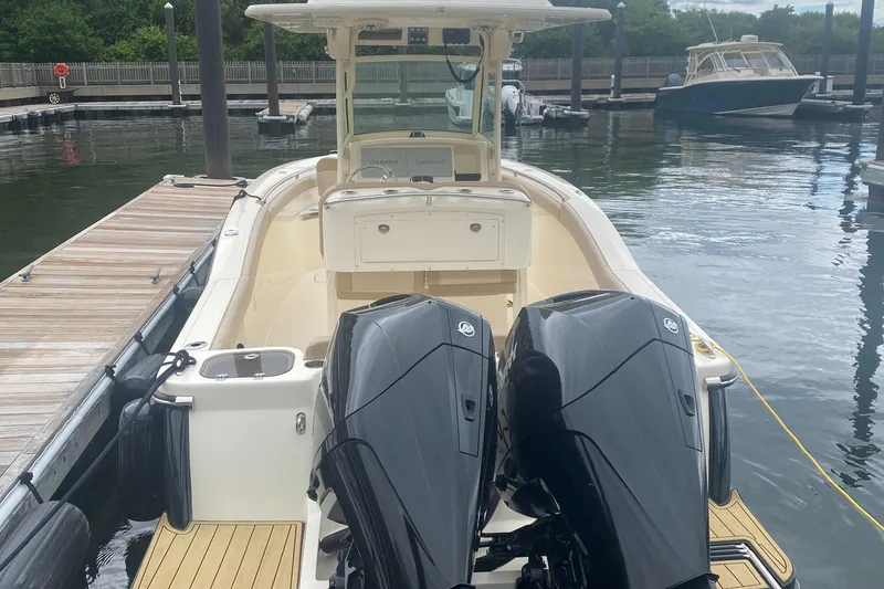 Slide: The Image of 2022 Scout 255 LXF boat with dual engines docked at a marina. - 5