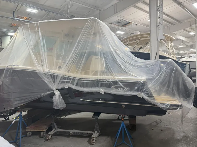 Slide: The Image of 2022 Scout 255 LXF boat covered in plastic in a storage facility. - 6