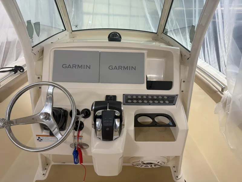 Slide: The Image of 2022 Scout 255 LXF boat dashboard with Garmin displays and steering wheel. - 7