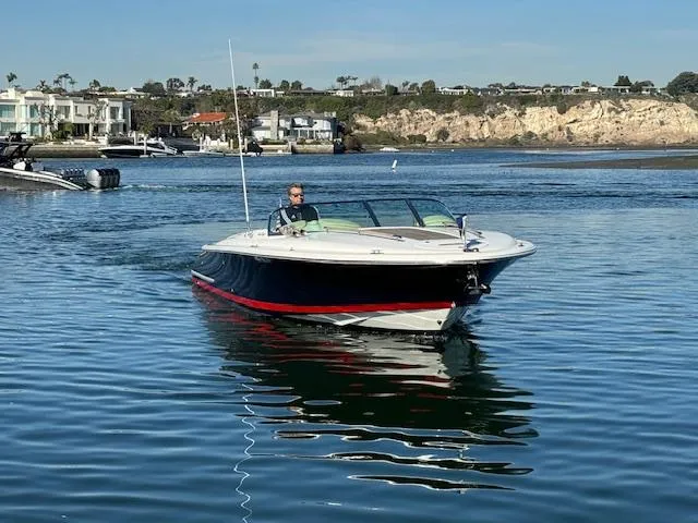 Slide: The Image of 2007 Chris-Craft Corsair 28 on calm water with coastal backdrop. - 2