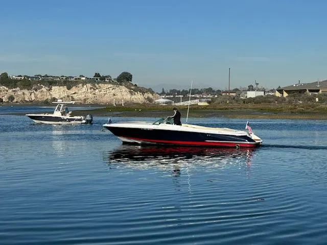 Slide: The Image of 2007 Chris-Craft Corsair 28 on calm water, coastal landscape in background. - 7