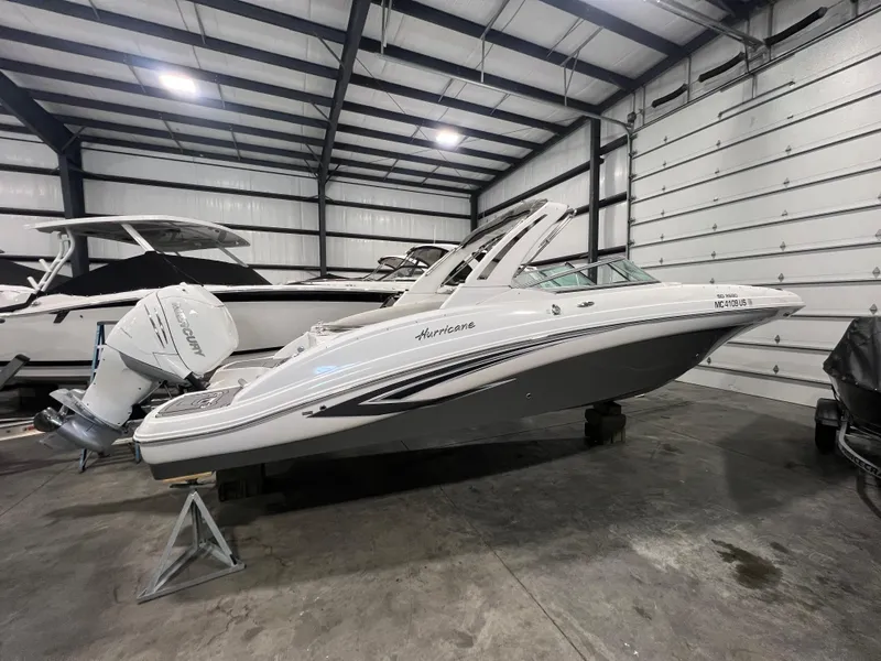 Slide: The Image of 2021 Hurricane SunDeck 2690 OB boat in a spacious indoor storage facility. - 1