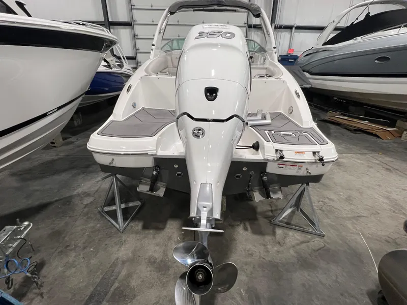 Slide: The Image of 2021 Hurricane SunDeck 2690 OB boat in storage, rear view with outboard motor. - 2
