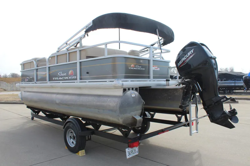 Slide: The Image of 2022 Sun Tracker Party Barge 18 DLX pontoon boat on trailer, featuring Mercury outboard motor. - 5