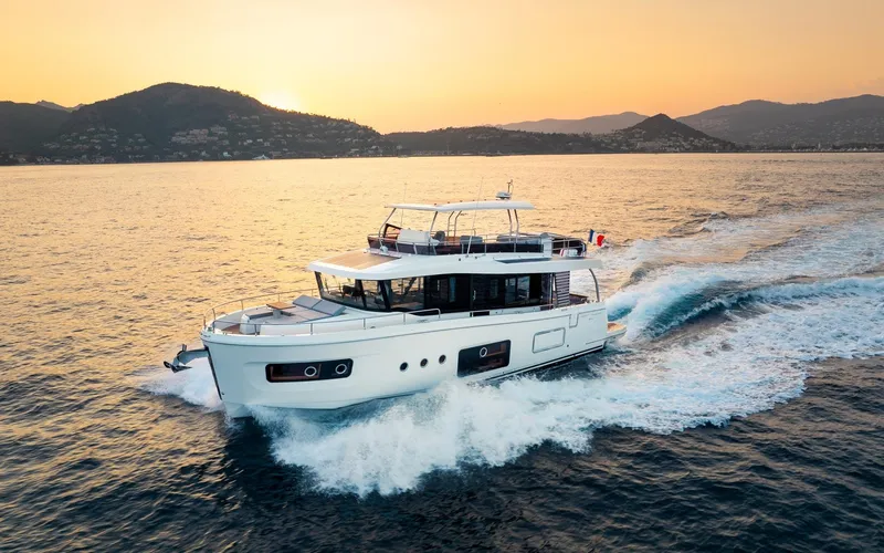 Slide: The Image of 2026 Beneteau Swift Trawler 54 cruising at sunset on open water. - 4