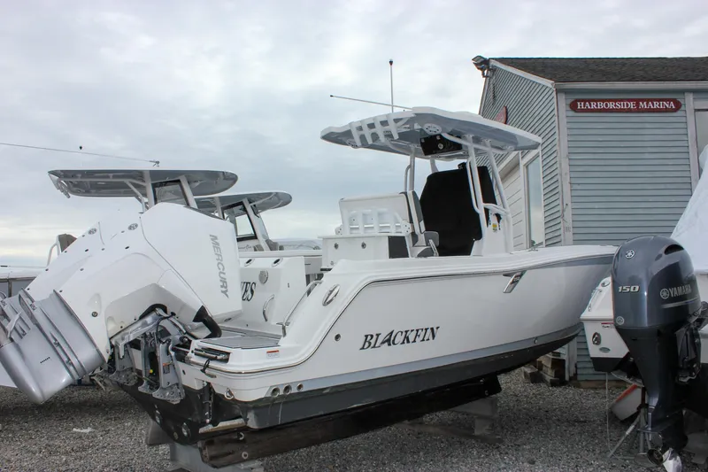 Slide: The Image of 2023 Blackfin 252 CC boat at Harborside Marina, featuring dual outboard motors. - 0