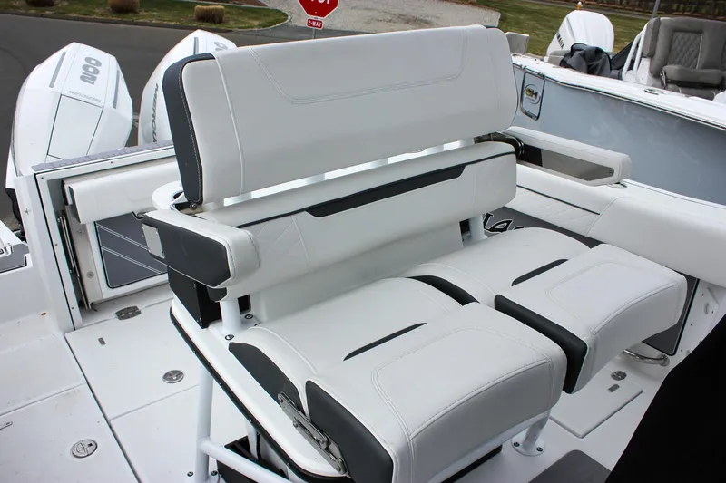 Slide: The Image of 2023 Blackfin 252 CC boat seating with white and black cushioned design. - 16