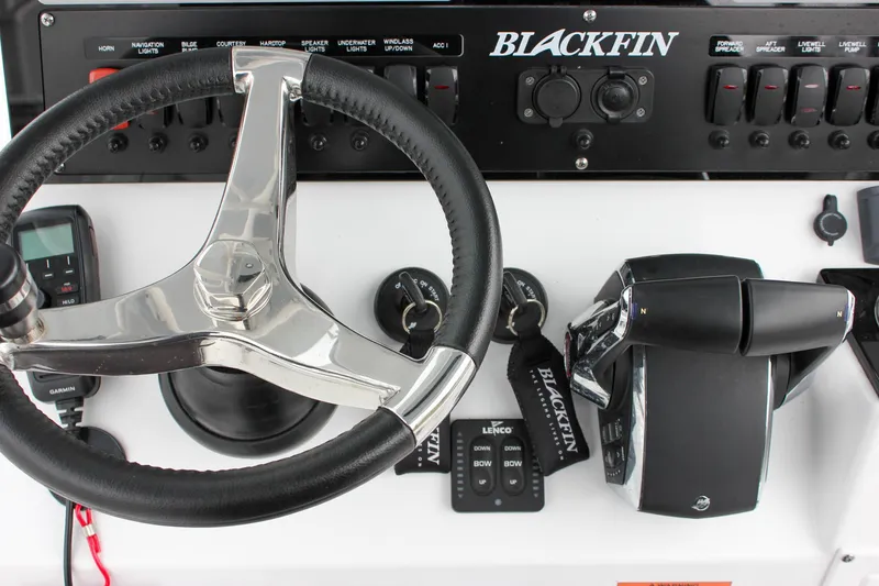 Slide: The Image of 2023 Blackfin 252 CC boat dashboard with steering wheel and control panel. - 22