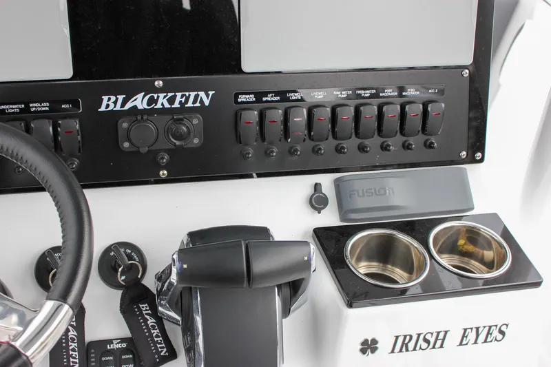 Slide: The Image of 2023 Blackfin 252 CC boat dashboard with controls, cup holders, and "Irish Eyes" label. - 23