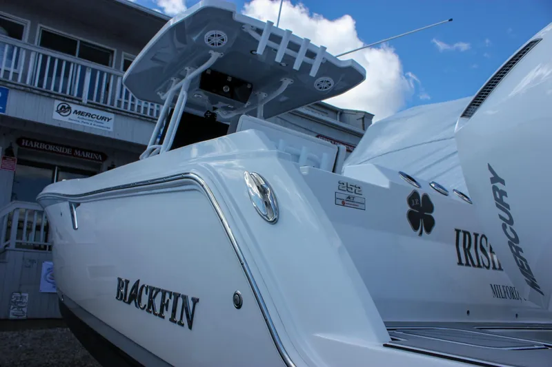 Slide: The Image of 2023 Blackfin 252 CC boat with Mercury engines, docked at a marina under a blue sky. - 3