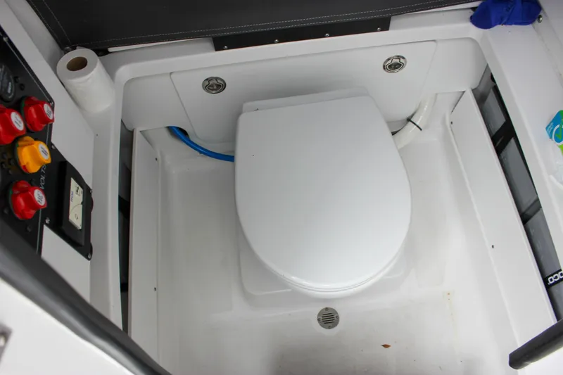 Slide: The Image of 2023 Blackfin 252 CC boat interior with a compact marine toilet setup. - 36